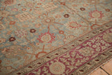 Antique distressed Yezd carpet detail: dusty blue field with Safavid palmettes and burgundy border.