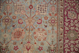 Distressed antique Yezd carpet section, with faded blue palmettes and burgundy floral border.