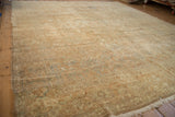 Distressed Tabriz carpet showing worn gold wash floral palmettes and subtle sea foam green tones.