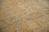 Distressed Tabriz carpet pile, showing worn palmettes in faded sea foam and coffee brown.