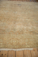 Faded floral palmettes and low pile texture of a distressed Gold Wash Tabriz.