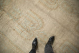 Distressed vintage Oushak rug texture with antique ivory, beige, and faded powder blue patterns.