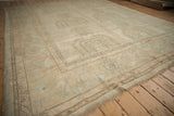 Detail of vintage distressed Oushak carpet with softened ivory and powder blue palmette pattern.