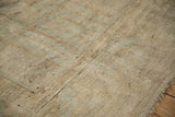 Distressed Oushak carpet texture showing beige, sand, and faint powder blue tones.
