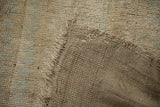 Distressed Oushak rug showing hand-knotted pile texture and woven reverse.