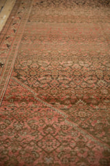 Angled view showing the worn texture and Herati design on a distressed Persian Malayer carpet.