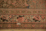 Detail of a small hole with visible foundation in the worn pile of a distressed Malayer carpet.