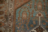 Vintage distressed Hamadan rug detail, muted blue field, terracotta border, abstract motifs, worn pile.