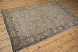 Distressed Sarouk rug corner view, showing rippled selvage and Gol Ferang border.