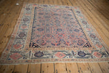 Antique Distressed Malayer rug corner, displaying an ivory border with blush and navy floral vinery.