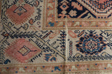 Antique Distressed Malayer rug detail: textured floral and geometric pattern in blush, navy, and beige.