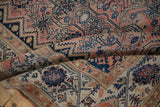 Distressed antique Malayer rug's pile showing time-softened blush, navy, and sand floral vinery.