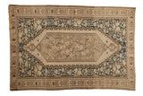 Antique distressed Malayer rug with a floral medallion, birds, and navy details on an ivory field.