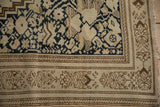 Worn hand-knotted pile on an antique Malayer rug's corner with a floral blossom border.