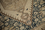Even wear to the knot heads and a stylized bird on an antique distressed Malayer rug.