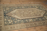 Elongated ivory medallion and traditional navy floral motifs on a distressed Malayer rug.