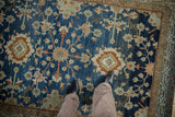Heavy abrashes across the floral patterns of a distressed vintage Hamadan rug.