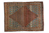 Antique Distressed Hamadan rug featuring a lattice medallion on a blue field with stylized Mahi-mahi motifs.