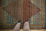 Detailed lattice work and Mahi-mahi motifs on a distressed antique Persian Hamadan rug.