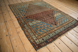 Antique Hamadan rug with a rust lattice medallion and blue corner spandrels featuring Mahi-mahi designs.