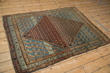 Antique Persian Hamadan rug from a high angle, showing the full pattern layout and colors.