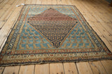 Antique Persian Hamadan rug at an angle, detailing the Mahi-mahi field and central lattice medallion.
