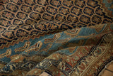 A folded view contrasting the lattice field and aquatic blue Mahi-mahi patterns of a Hamadan rug.