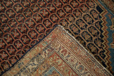 Corner of the antique Hamadan rug folded to show the hand-knotted reverse weave.