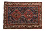 Antique Persian Afshar rug with an interconnected double medallion in madder red on a sapphire blue field.