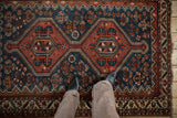 A perspective on the low pile texture of an antique Afshar rug's red medallion and blue field.