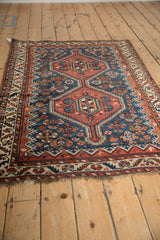 The low-pile wool and bold geometric pattern of an antique Persian Afshar rug with red double medallions.