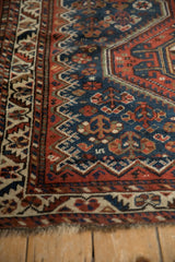 Corner view of an antique Afshar rug showing the colorful serrated leaf border and time-softened pile.