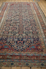 Perspective view down the length of the antique Malayer carpet, showing the balanced Herati design.