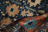 Textured pile of folded vintage Mehriban rug, with teal oversized palmette on madder root rust.
