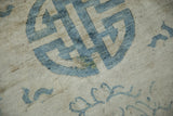 Distressed wool pile and a small restored patch on an antique Peking rug's blue medallion.