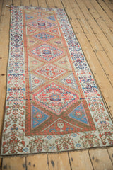 Geometric stepped corner spandrels and henna plant border on antique Persian rug.