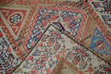 Folded antique Northwest Persian rug showing hand-knotted pile, foundation, and muted geometric patterns.