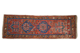 Antique Northwest Persian runner with two indigo blue hexagonal medallions on a polychromatic brick red field.