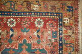 Corner of an antique Persian runner showing geometric flowers and areas of worn pile and foundation.