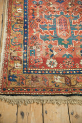 Corner of an antique Persian runner showing the cotton selvage, original fringe, and time-softened pile.