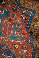 Folded view showcasing the dense wool pile and geometric patterns of an antique Persian runner.