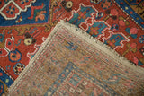 Corner of an antique Persian runner showing the hand-knotted foundation and brick red pile.