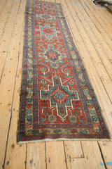 Vintage Heriz runner's cherry red field, geometric medallions, serrated leaves, and sky blue blossoms.