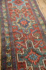 Vintage Heriz runner field in cherry red with geometric contour of leaves and blossoms.