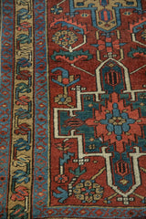 Vintage Heriz rug showing geometric serrated leaves and floral motifs in cherry red, sky blue.