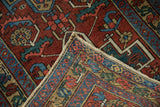Vintage Heriz runner corner, showing red, blue geometric floral pattern, foundation, and selvage wear.