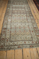 Distressed geometric diamond pattern on vintage Caucasian runner with areas of low pile.