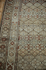 Distressed Caucasian runner with geometric border and diamond lattice pattern.