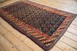 Clearly detailed pawn border motif and henna plant field of the vintage Kurdish rug.