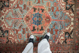 Vintage Heriz rug: hexagonal sapphire blue medallion, ruby red field, and pomegranate blossoms.
